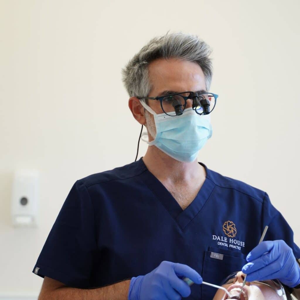 Dentist with loupes and mask treating patient at Dale House